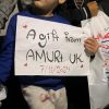 child holding bag and label: Gift from AMURT UK