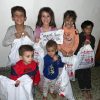 children holding bags and one child holding label: Gift from AMURT UK